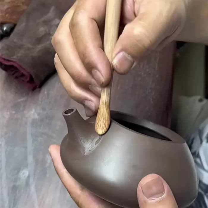 Poterie en argile violette, outils spéciaux de fabrication, bricolage fait à la main pour faire du théière en céramique, théière de nettoyage du mur intérieur, outil de grattage du fond