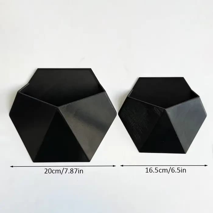Le pot de fleurs hexagonal noir à fixer au mur a un design simple et unique. Sa structure perforée f